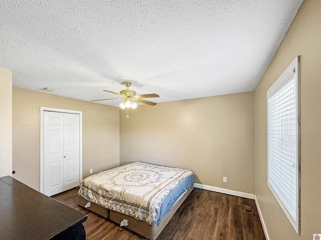 bedroom featuring a textured ceiling, wood finished floors, a closet, baseboards, and ceiling fan