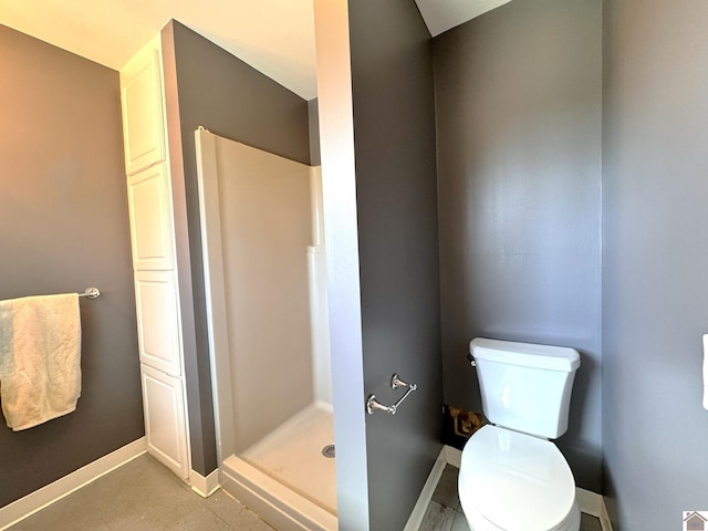 full bathroom featuring a shower stall, toilet, and baseboards