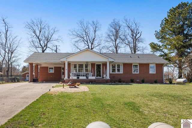 single story home with driveway, brick siding, a porch, and a front yard