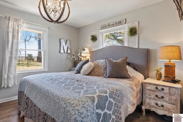 bedroom with a chandelier, multiple windows, dark wood finished floors, and baseboards