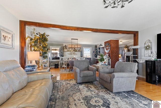 living area featuring beamed ceiling, wood finished floors, and a chandelier