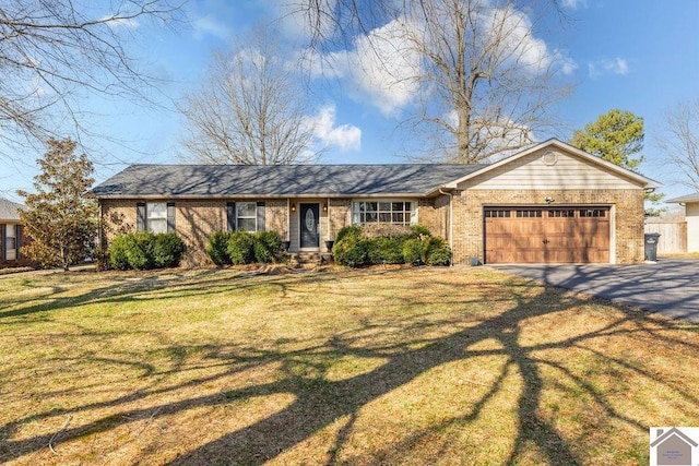 single story home with brick siding, an attached garage, driveway, and a front yard