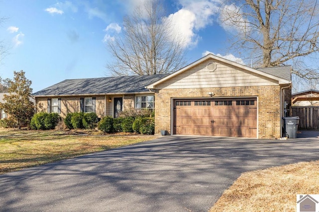 single story home featuring brick siding, driveway, and an attached garage