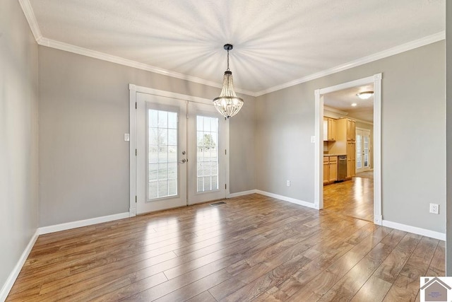 spare room featuring visible vents, light wood-type flooring, baseboards, and ornamental molding