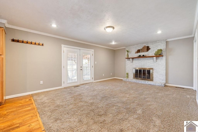 unfurnished living room featuring french doors, baseboards, a textured ceiling, and ornamental molding