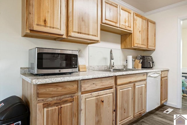 kitchen featuring stainless steel microwave, light brown cabinets, crown molding, dishwasher, and a sink