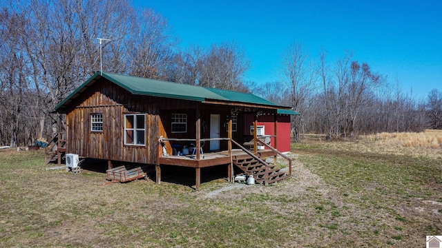 rear view of house with a lawn and board and batten siding