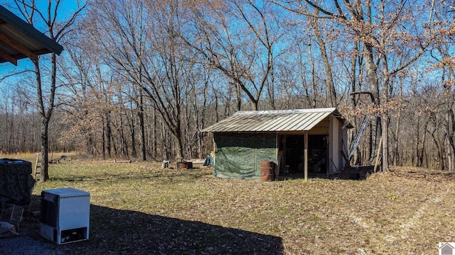 view of yard featuring an outbuilding and a forest view