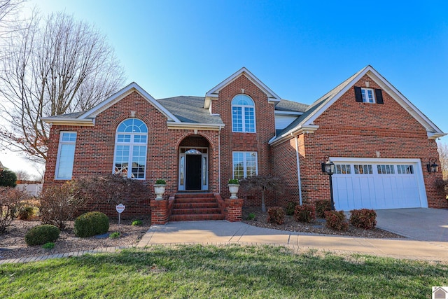 traditional-style house featuring concrete driveway, a garage, brick siding, and roof with shingles