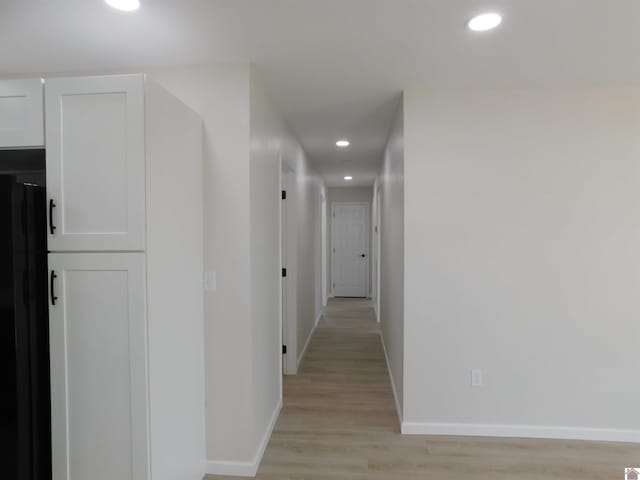 corridor with light wood finished floors, recessed lighting, and baseboards