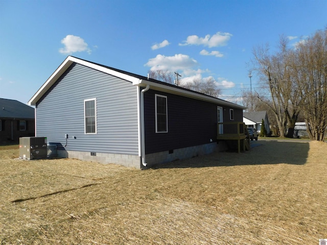 view of side of home featuring central air condition unit, a yard, and crawl space