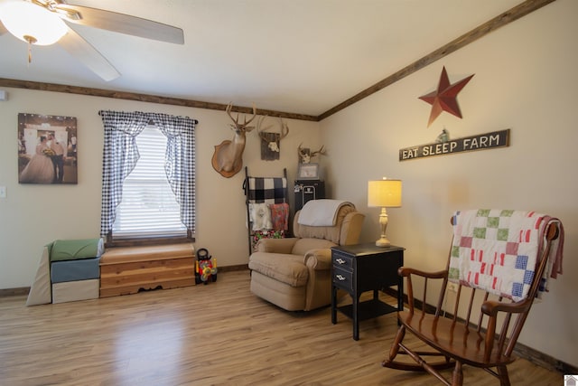 living area featuring baseboards, wood finished floors, a ceiling fan, and vaulted ceiling