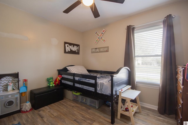 bedroom with ceiling fan, baseboards, and wood finished floors