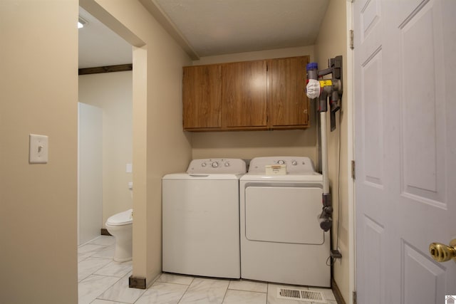 washroom with washer and dryer, visible vents, cabinet space, and marble finish floor