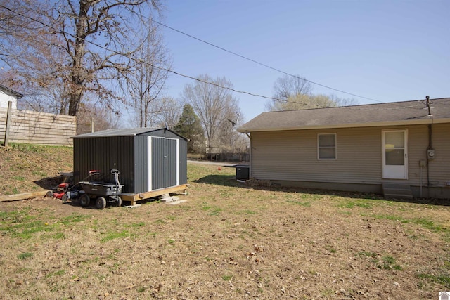 view of yard featuring a storage unit, an outdoor structure, and fence