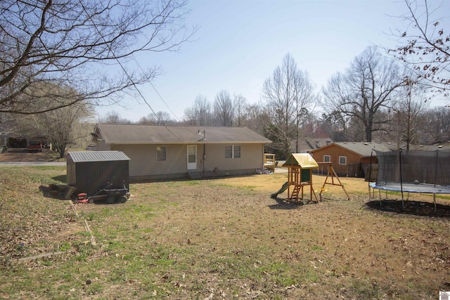 back of house with a lawn, a playground, and a trampoline