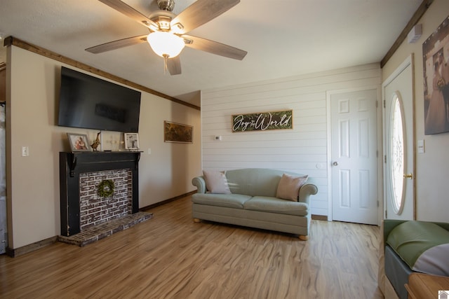 living room with baseboards, a ceiling fan, and wood finished floors