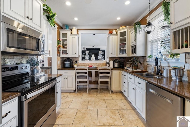 kitchen with backsplash, stainless steel appliances, crown molding, and a sink