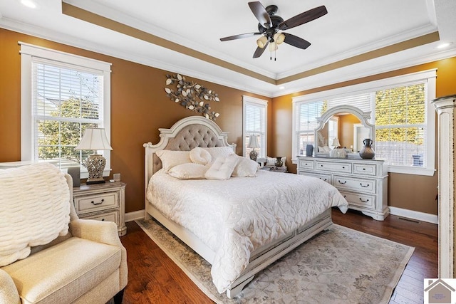 bedroom featuring a ceiling fan, baseboards, ornamental molding, dark wood-type flooring, and a raised ceiling