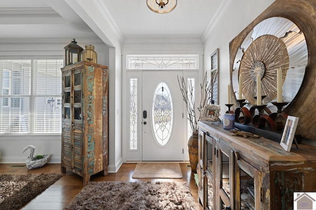 foyer featuring baseboards, wood finished floors, and ornamental molding