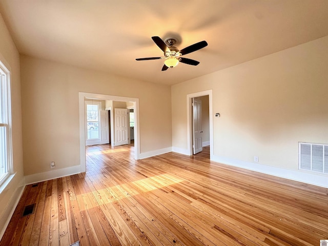 empty room featuring visible vents, baseboards, and light wood-style floors