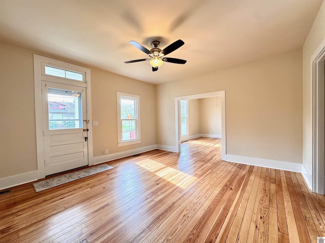 foyer entrance with light wood-style flooring, baseboards, and ceiling fan