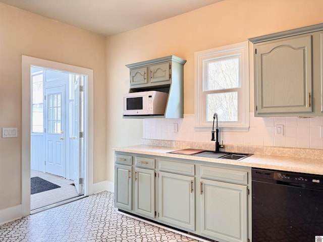 kitchen featuring a sink, white microwave, dishwasher, and light countertops