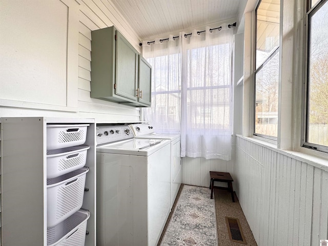 laundry room with washer and clothes dryer, visible vents, and cabinet space