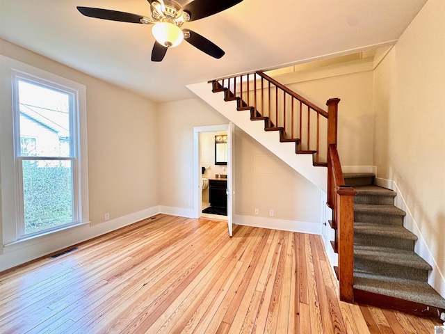 interior space with light wood finished floors, visible vents, and stairs