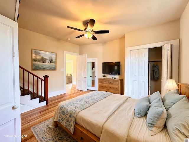 bedroom featuring a ceiling fan, baseboards, a closet, and light wood finished floors