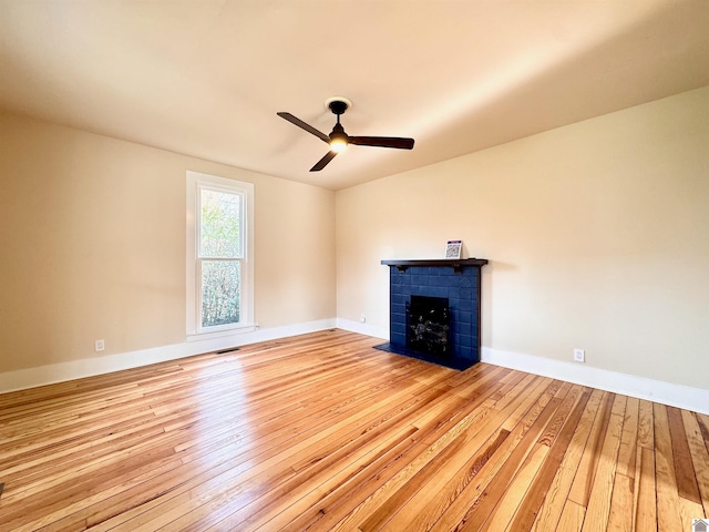 unfurnished living room with baseboards, a ceiling fan, hardwood / wood-style floors, and a fireplace