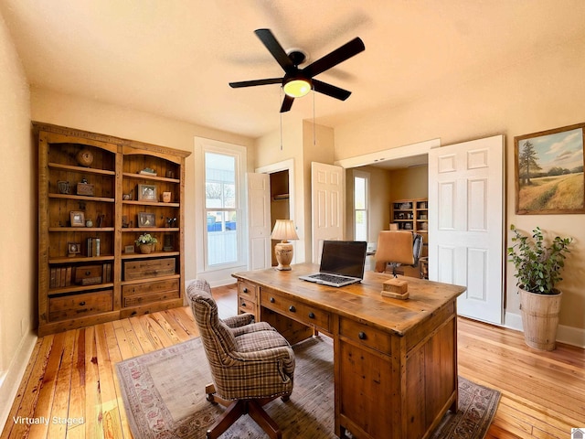 office area with a ceiling fan, light wood-style floors, and baseboards