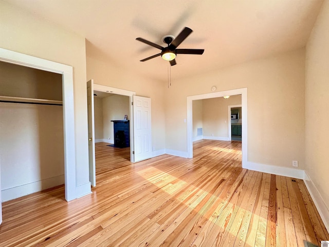unfurnished bedroom featuring visible vents, baseboards, a closet, and light wood finished floors