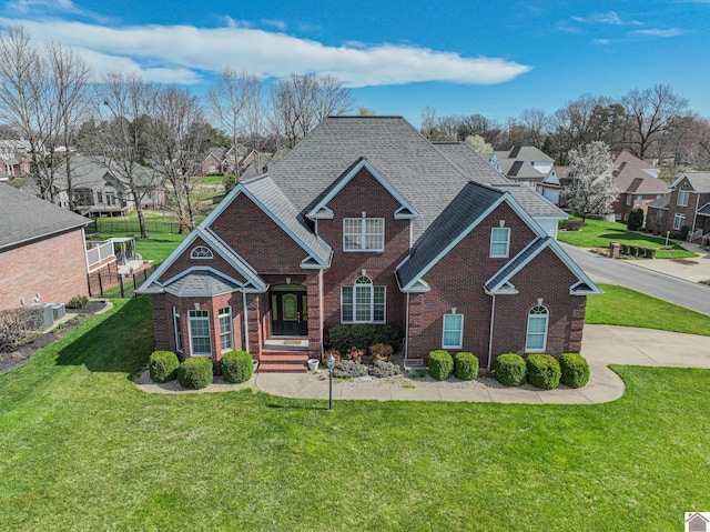 traditional home featuring brick siding, a front lawn, and a residential view