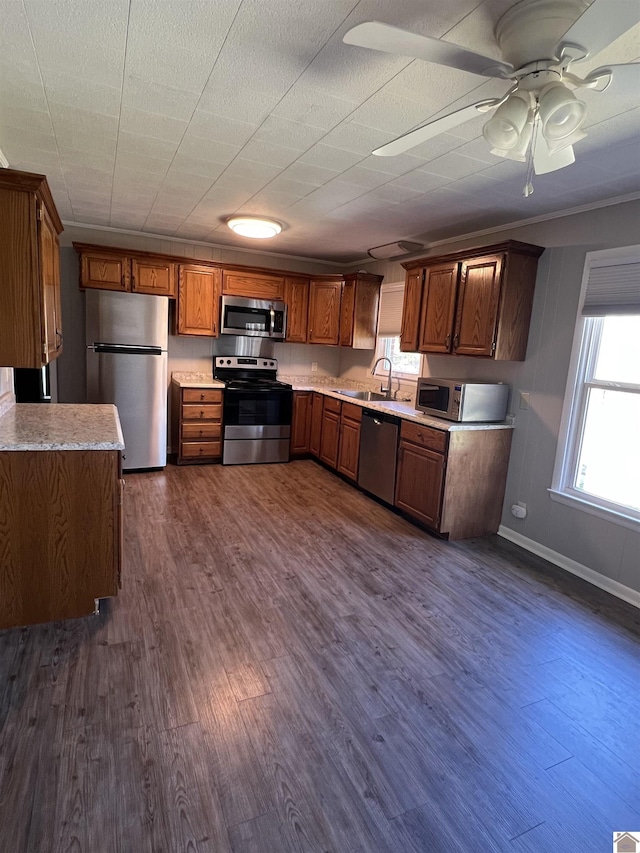 kitchen with light countertops, baseboards, dark wood finished floors, a sink, and appliances with stainless steel finishes