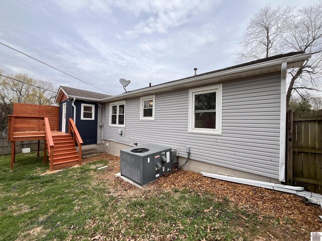 back of property featuring a lawn, fence, and a wooden deck