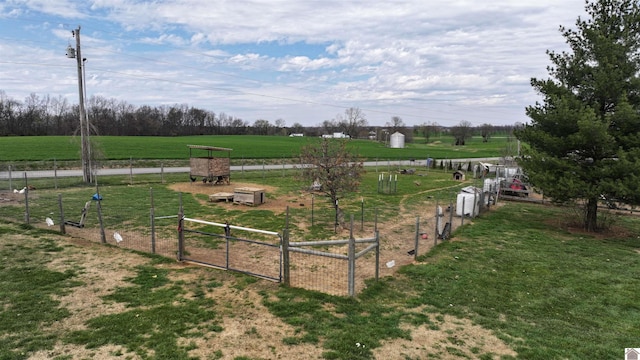 view of yard with a gate, fence, and a rural view
