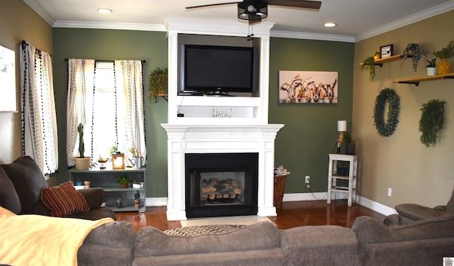 living area featuring a fireplace with flush hearth, ornamental molding, wood finished floors, and a ceiling fan
