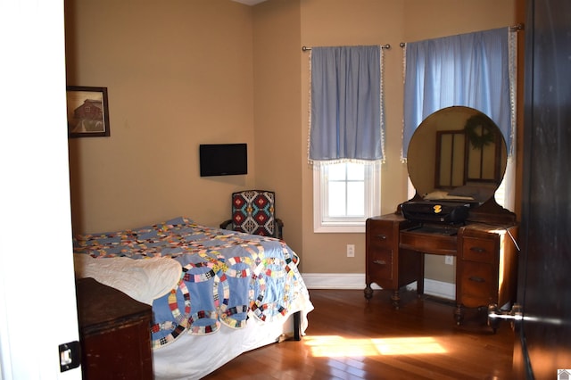 bedroom featuring baseboards and wood finished floors