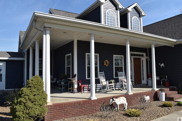 exterior space with covered porch and a shingled roof