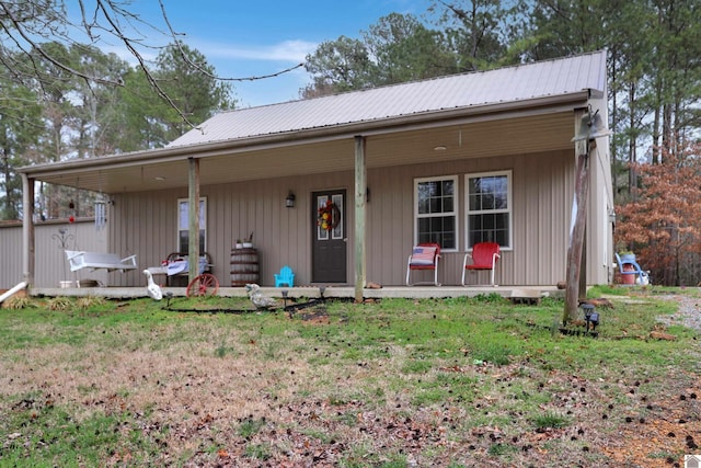 view of front of house featuring metal roof, a front yard, and a porch