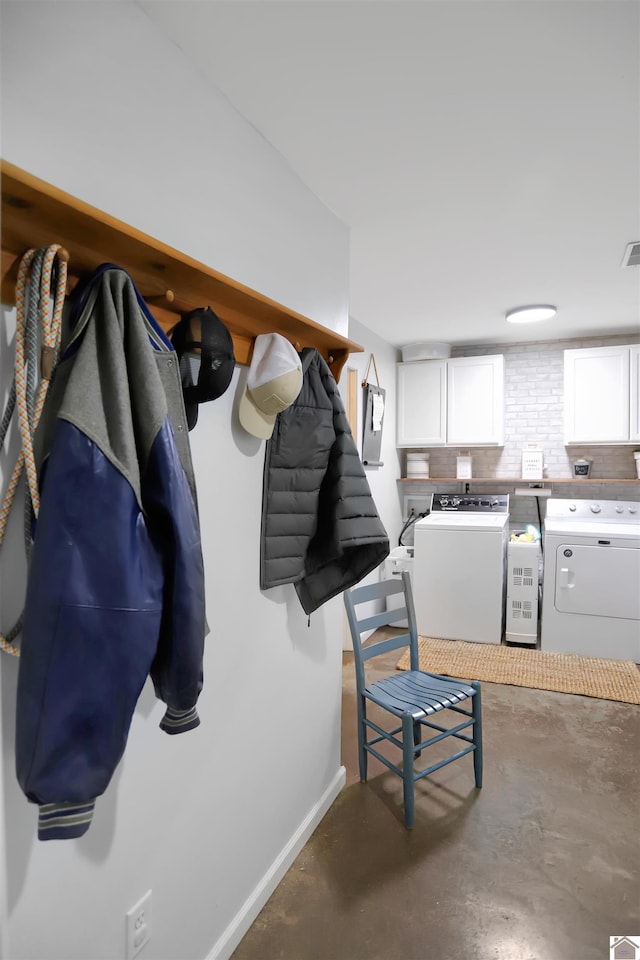 mudroom featuring concrete floors, washer and clothes dryer, and baseboards