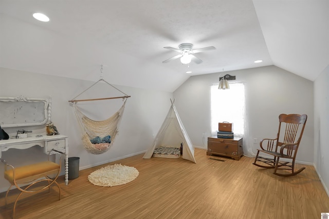 interior space with baseboards, vaulted ceiling, wood finished floors, and a ceiling fan