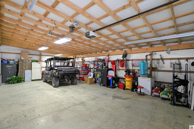 garage with a garage door opener and freestanding refrigerator