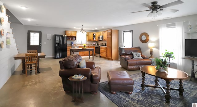 living area with a ceiling fan, recessed lighting, finished concrete floors, and a wealth of natural light