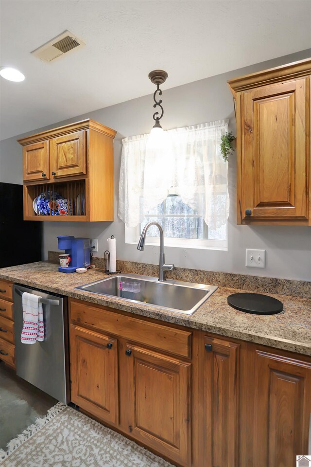 kitchen featuring a sink, pendant lighting, stainless steel dishwasher, brown cabinets, and visible vents