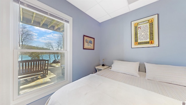 bedroom with access to exterior and a paneled ceiling