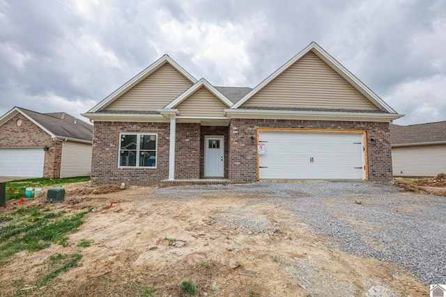 craftsman house with a shingled roof, driveway, and brick siding