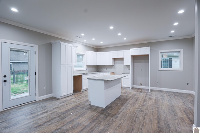kitchen featuring recessed lighting, ornamental molding, white cabinetry, and a kitchen island