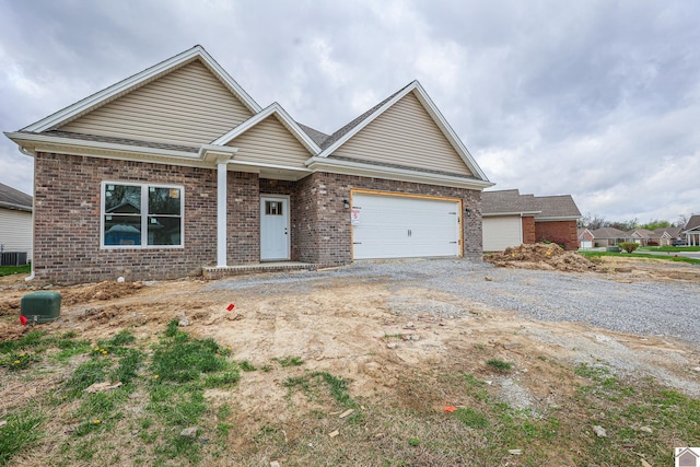 craftsman-style home with brick siding, an attached garage, and driveway
